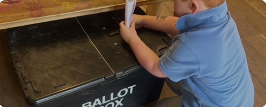 Child putting wooden pegs into a block