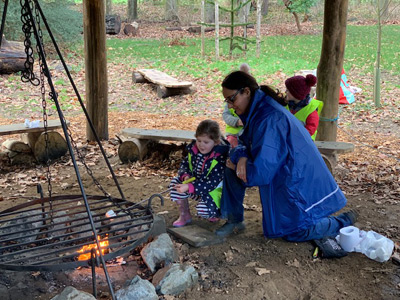 Child and teacher looking at fire